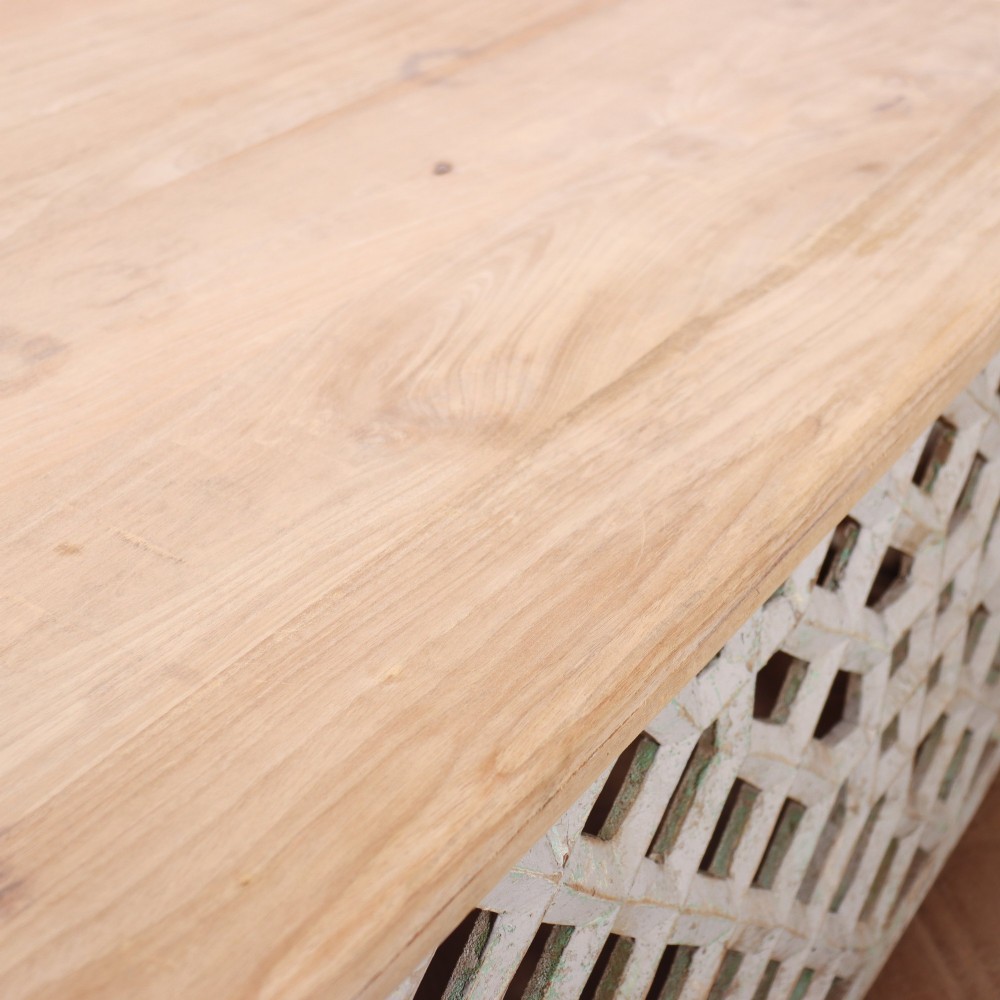 A low rectangular coffee table featuring a plain natural wood top supported by a whitewashed base with geometric lattice fretwork. View X