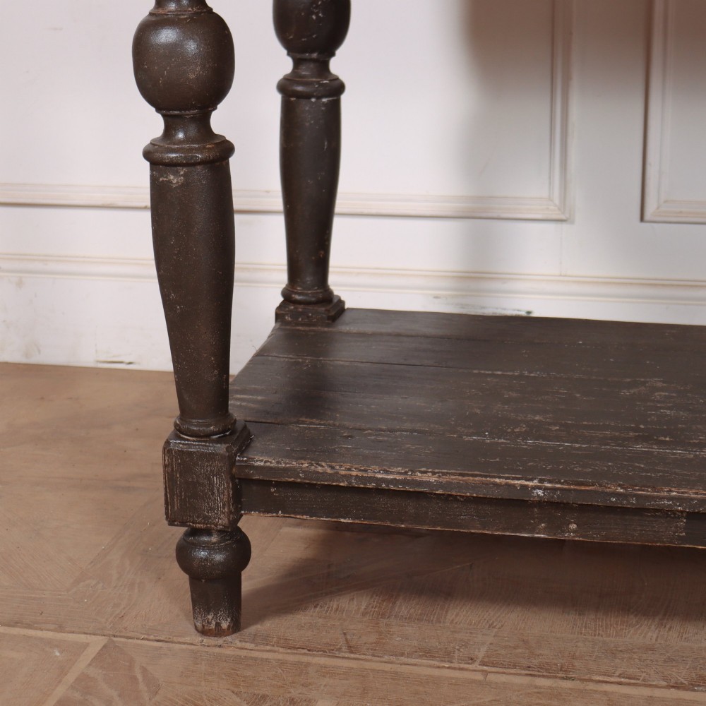 A French drapers table featuring a natural wood top, two shallow drawers with brass knobs, a dark grey painted base, turned legs, and a lower pot board shelf. View III
