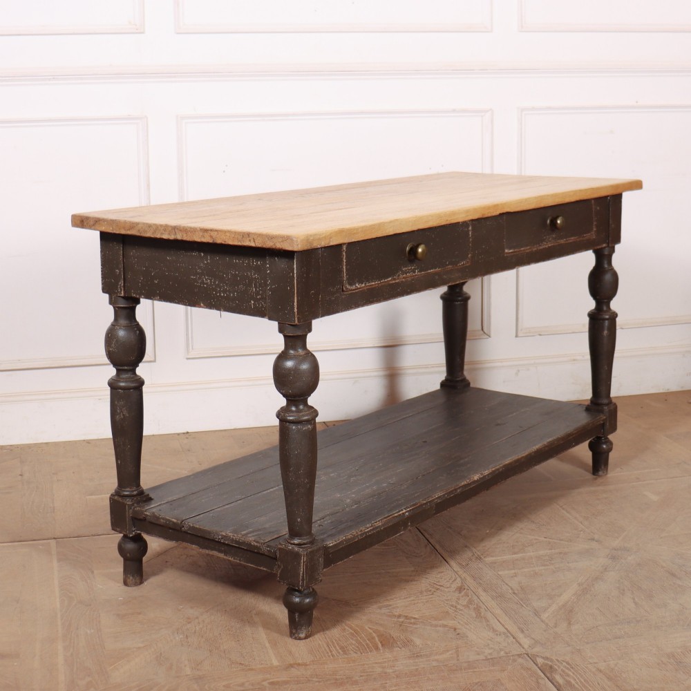 A French drapers table featuring a natural wood top, two shallow drawers with brass knobs, a dark grey painted base, turned legs, and a lower pot board shelf. View VI