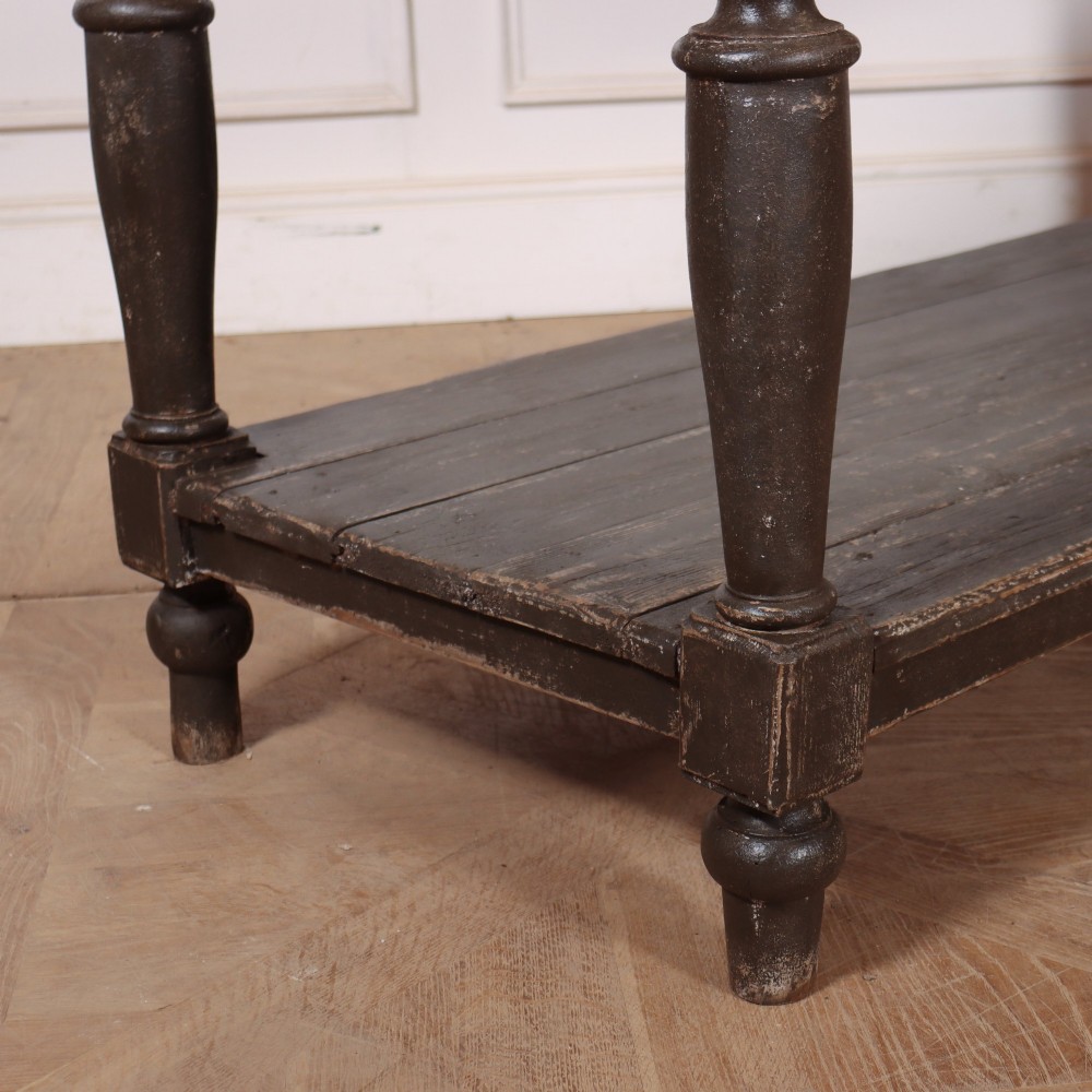 A French drapers table featuring a natural wood top, two shallow drawers with brass knobs, a dark grey painted base, turned legs, and a lower pot board shelf. View VII