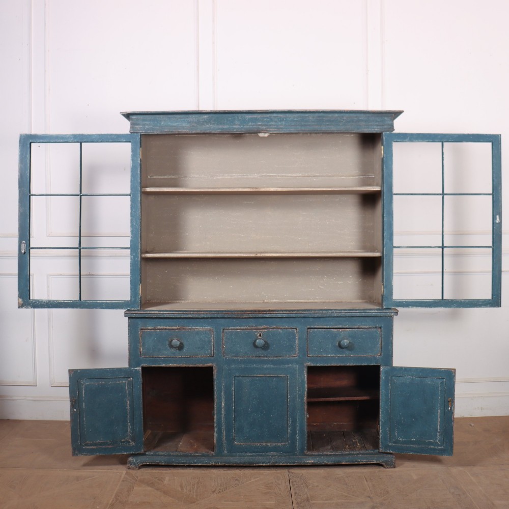 A blue-painted two-part timber dresser featuring an upper section with two glazed six-pane doors and a lower base with three drawers above three panelled cupboard doors. View VIII