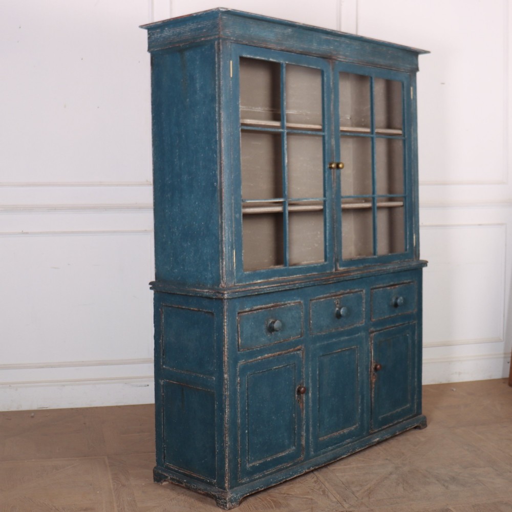 A blue-painted two-part timber dresser featuring an upper section with two glazed six-pane doors and a lower base with three drawers above three panelled cupboard doors. View X