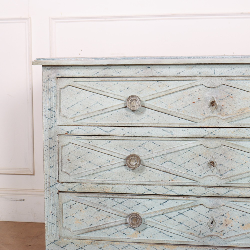 A pale blue painted Spanish commode with three drawers decorated with a distressed diamond lattice pattern and metallic ring pulls. View II