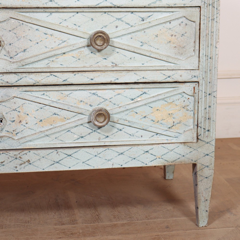 A pale blue painted Spanish commode with three drawers decorated with a distressed diamond lattice pattern and metallic ring pulls. View V