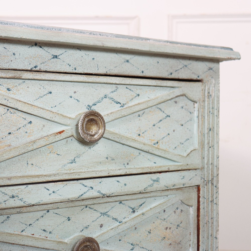 A pale blue painted Spanish commode with three drawers decorated with a distressed diamond lattice pattern and metallic ring pulls. View VII