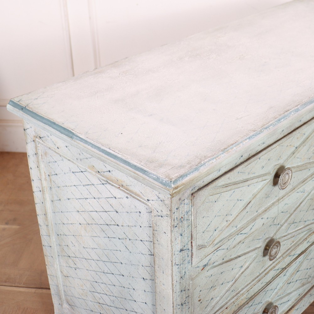 A pale blue painted Spanish commode with three drawers decorated with a distressed diamond lattice pattern and metallic ring pulls. View VIII