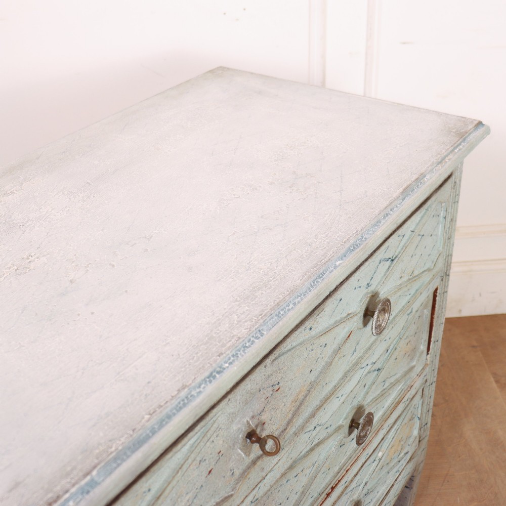 A pale blue painted Spanish commode with three drawers decorated with a distressed diamond lattice pattern and metallic ring pulls. View IX