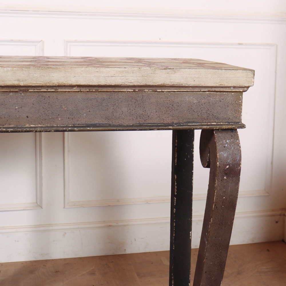 A pair of narrow Spanish painted wood console tables with curved upright supports, patterned top surfaces, and lower shelves. View II