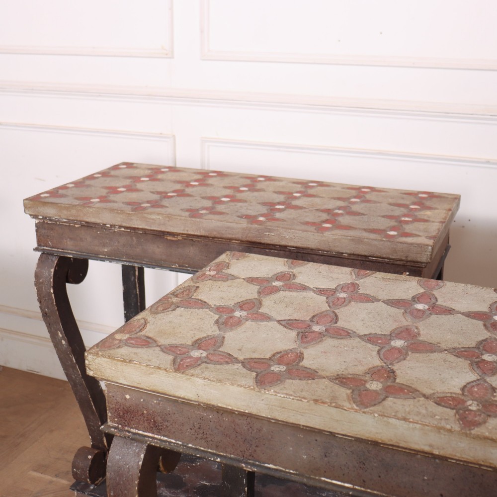 A pair of narrow Spanish painted wood console tables with curved upright supports, patterned top surfaces, and lower shelves. View VII