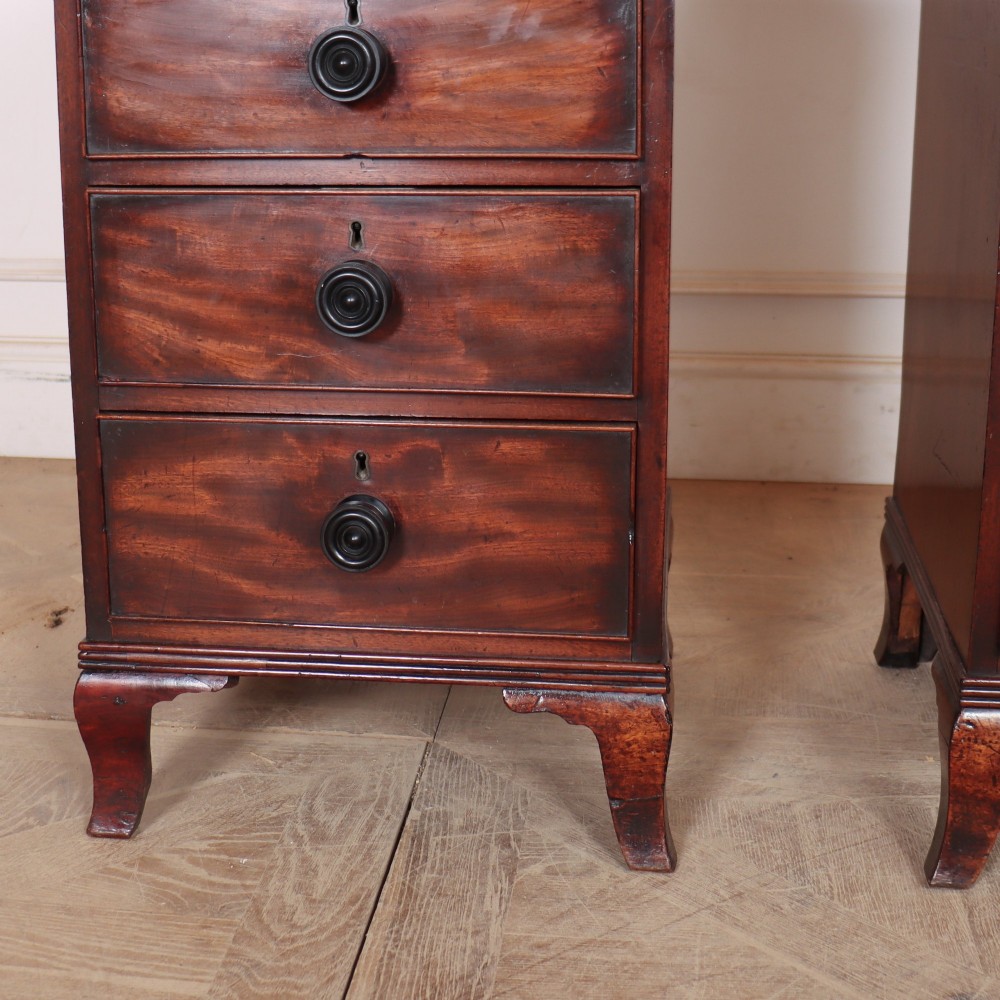 A matching pair of dark mahogany bedside chests, each featuring four drawers with turned wooden knobs and bracket feet. View V