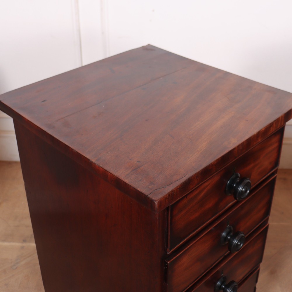 A matching pair of dark mahogany bedside chests, each featuring four drawers with turned wooden knobs and bracket feet. View VII