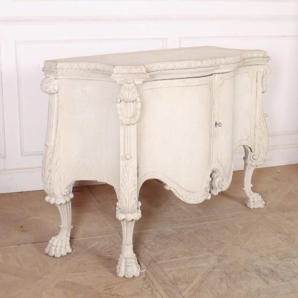 An off-white painted Italian Rococo side cabinet featuring carved acanthus leaf shoulders, a serpentine lower apron, double doors with painted blue trim, and prominent carved claw feet. View X