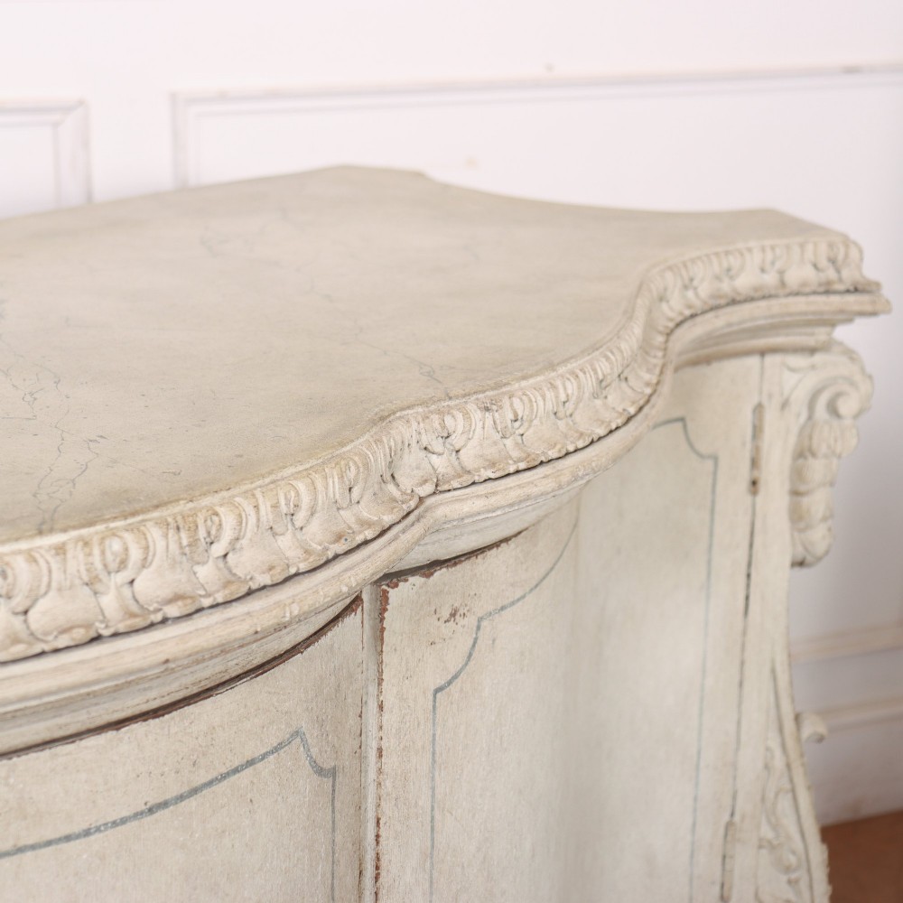 An off-white painted Italian Rococo side cabinet featuring carved acanthus leaf shoulders, a serpentine lower apron, double doors with painted blue trim, and prominent carved claw feet. View XIV
