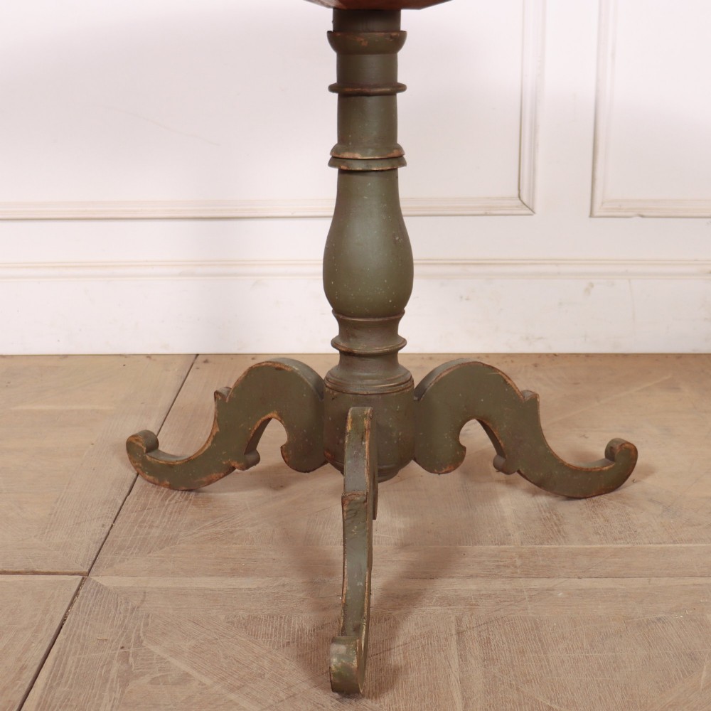 An antique Swedish painted wooden side table featuring a circular top, turned central pedestal, and scrolled tripod legs in a muted green finish. View II