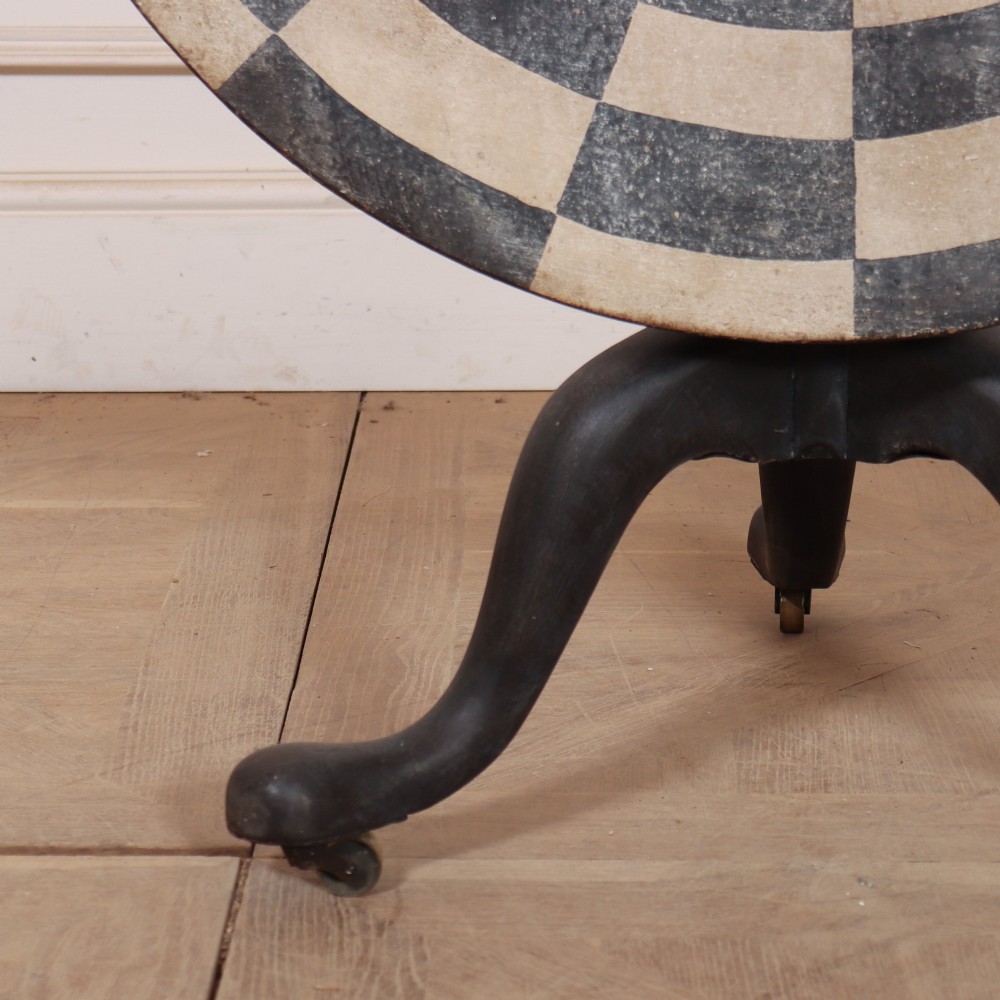 A circular tilt-top tripod table featuring a painted concentric checkerboard top in black and cream, supported by a dark three-legged base on castors. View II