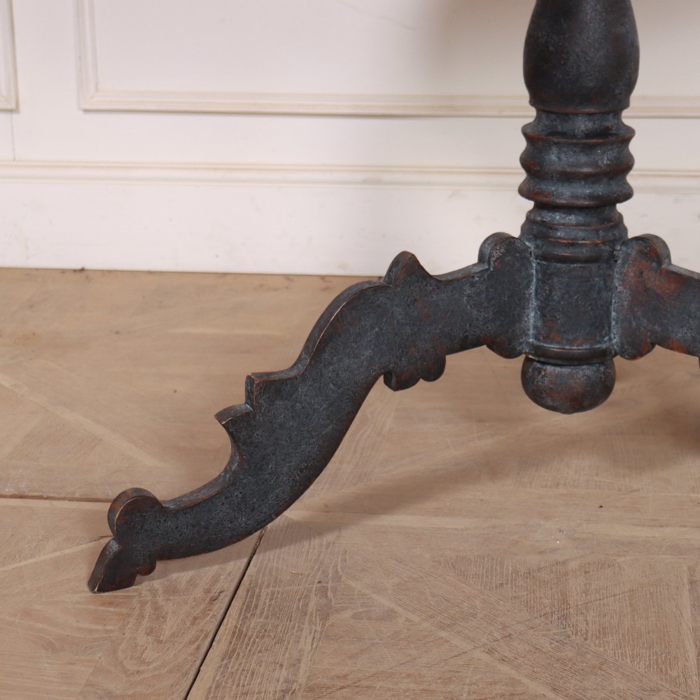 An antique Swedish round supper table featuring a dark distress-painted top set on a turned baluster pedestal with shaped tripod legs. View II