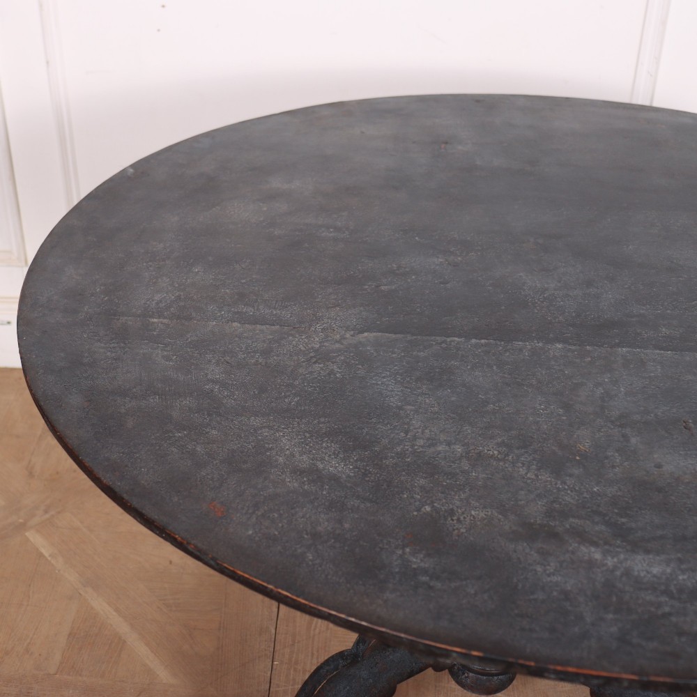 An antique Swedish round supper table featuring a dark distress-painted top set on a turned baluster pedestal with shaped tripod legs. View V