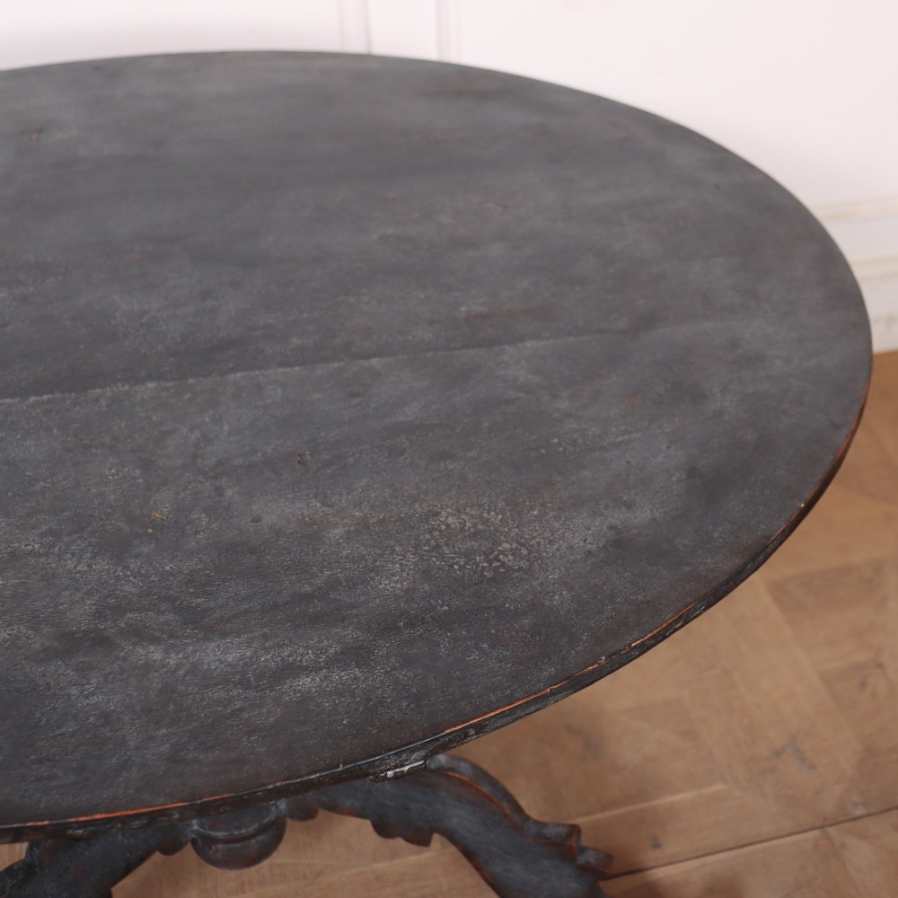 An antique Swedish round supper table featuring a dark distress-painted top set on a turned baluster pedestal with shaped tripod legs. View VI