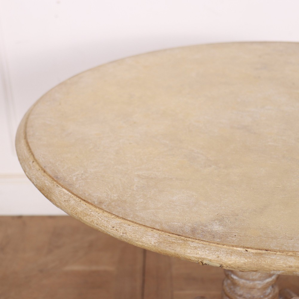 A circular painted Swedish side table featuring a turned central pedestal column resting on three carved scroll tripod legs with a distressed grey paint finish. View VI