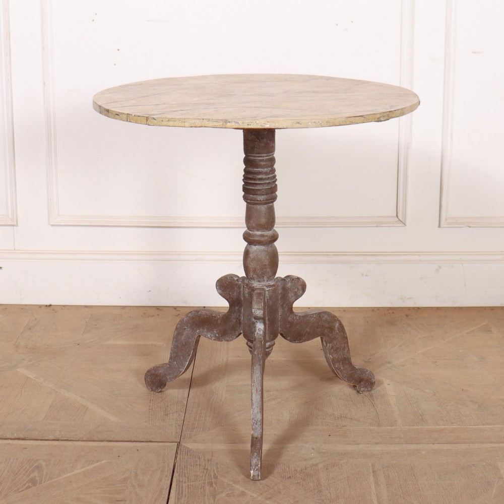 An antique Swedish painted lamp table featuring a circular top supported by a turned central column and three carved scrolled legs.