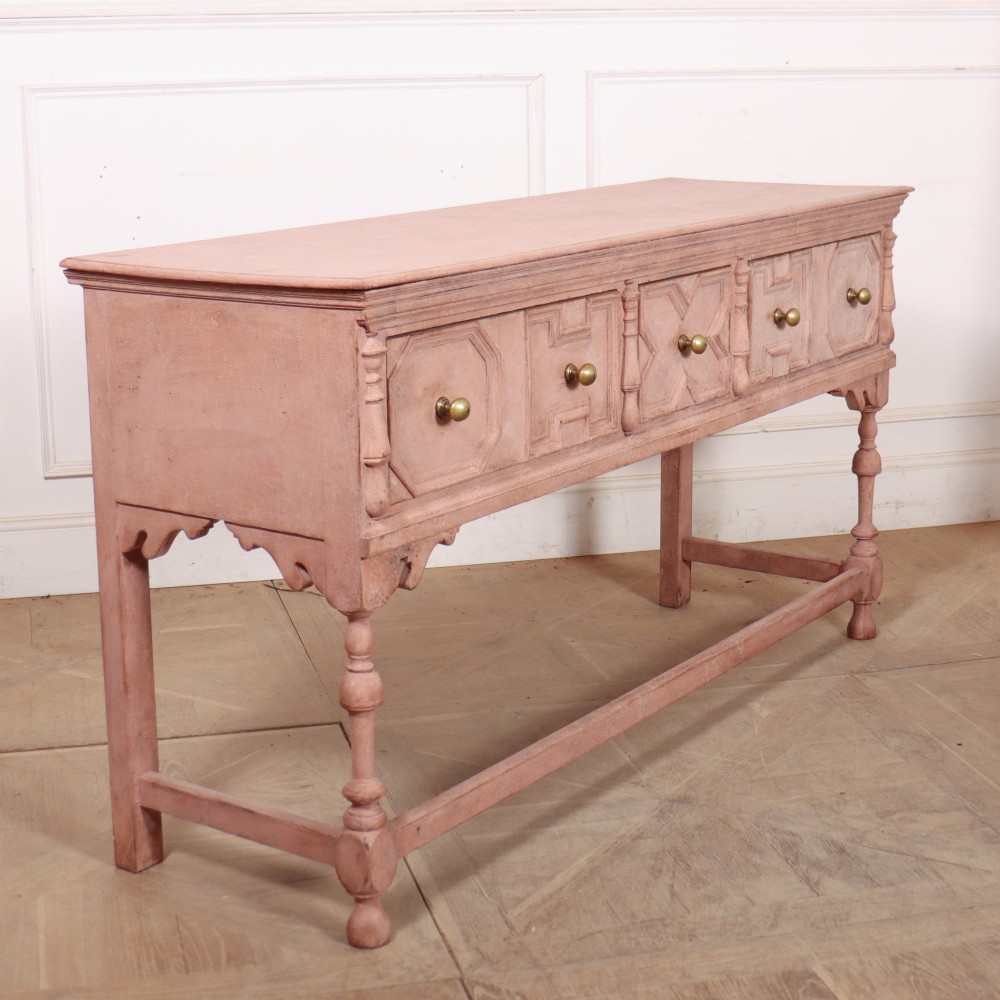A long English painted dresser base featuring five geometric mouldings across the drawer fronts, brass knobs, turned legs, and a low connecting stretcher. View VIII