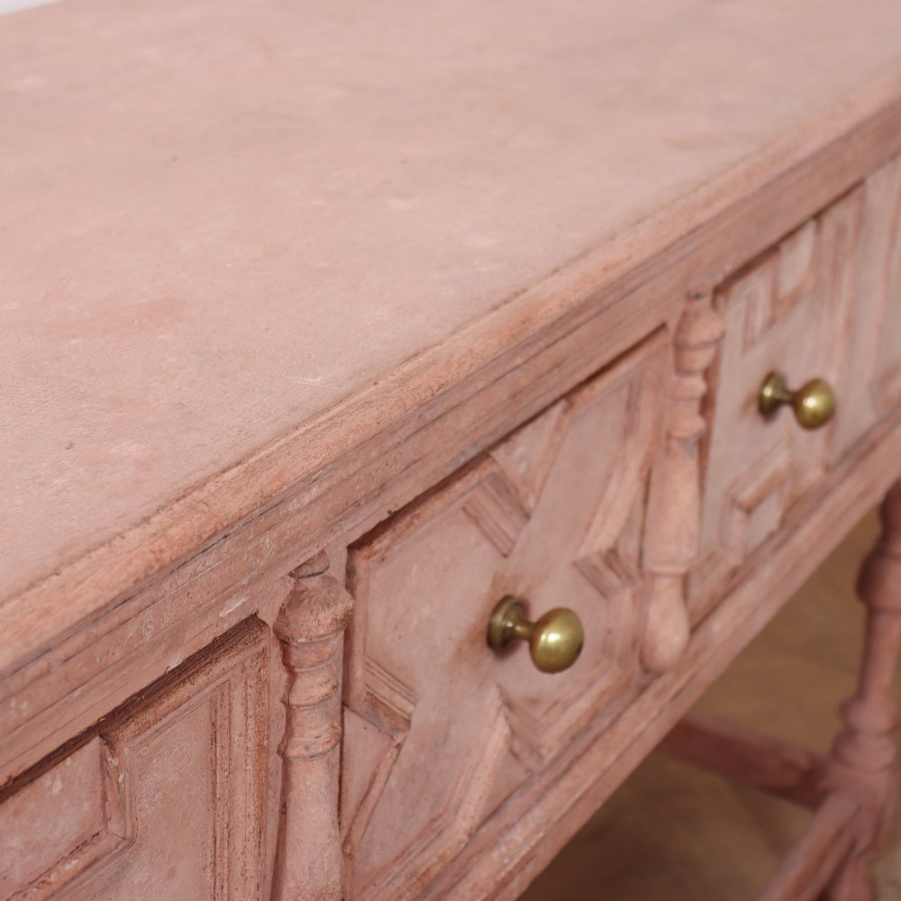 A long English painted dresser base featuring five geometric mouldings across the drawer fronts, brass knobs, turned legs, and a low connecting stretcher. View XI
