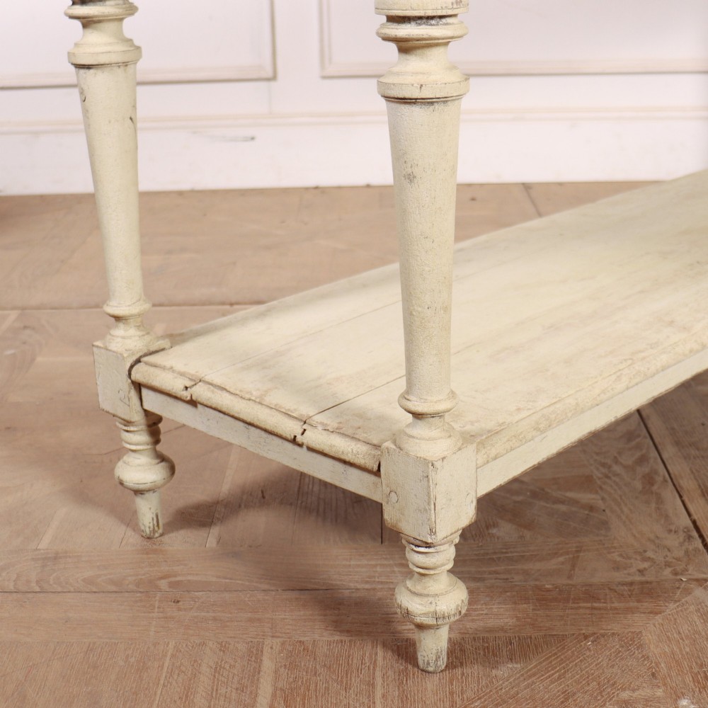 A long French painted drapers table featuring a natural pine top, a cream-painted base with turned legs, and a low open undershelf. View II