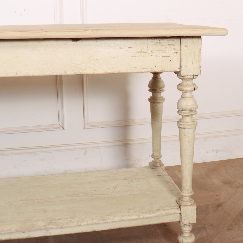 A long French painted drapers table featuring a natural pine top, a cream-painted base with turned legs, and a low open undershelf. View VIII
