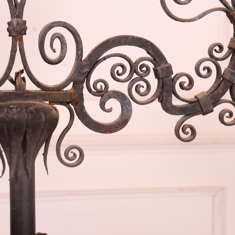 A tall dark wrought iron floor candelabra featuring scrollwork arms holding six candle sconces above a decorated stem and tripod scroll base. View VI