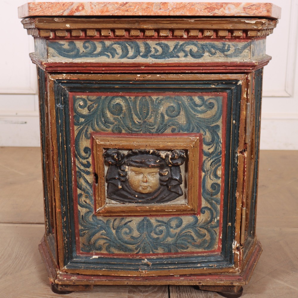 An antique Italian polychrome painted cabinet with a pink marble top, canted corners, and a central carved face mask panel. View II