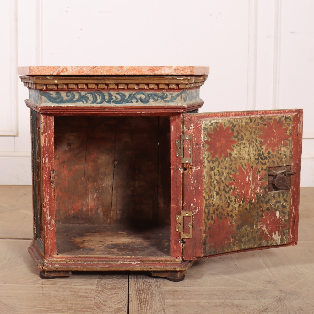 An antique Italian polychrome painted cabinet with a pink marble top, canted corners, and a central carved face mask panel. View V