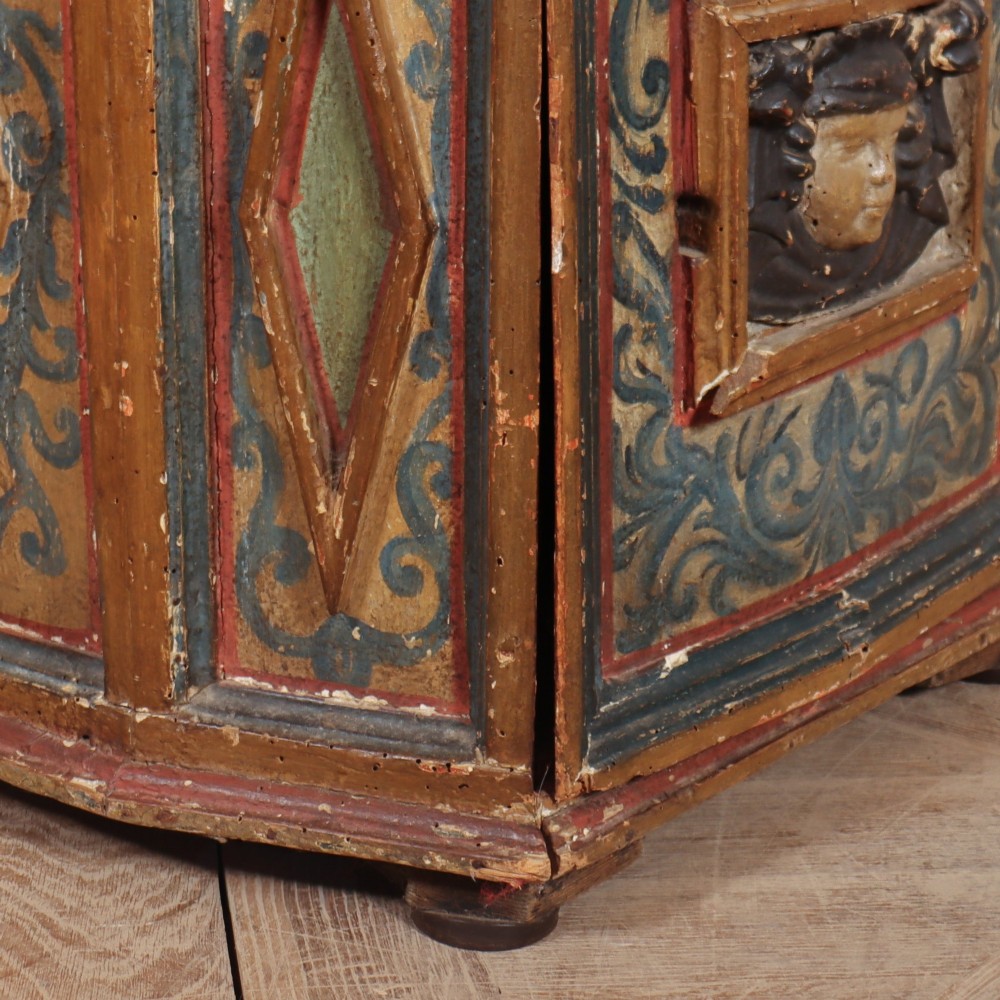 An antique Italian polychrome painted cabinet with a pink marble top, canted corners, and a central carved face mask panel. View VIII