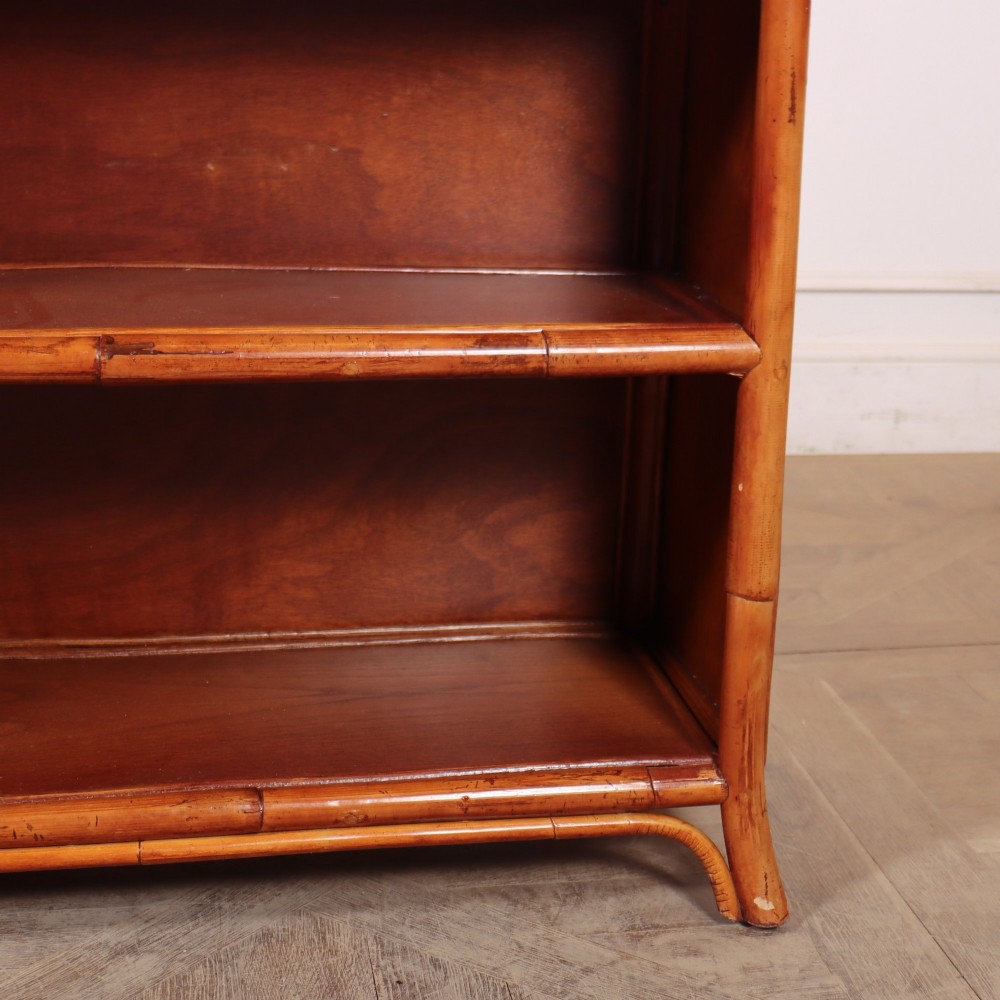 A pair of low vintage bamboo bookcases featuring woven cane tops and two open wooden shelves. View III