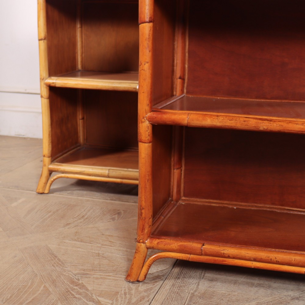 A pair of low vintage bamboo bookcases featuring woven cane tops and two open wooden shelves. View IV