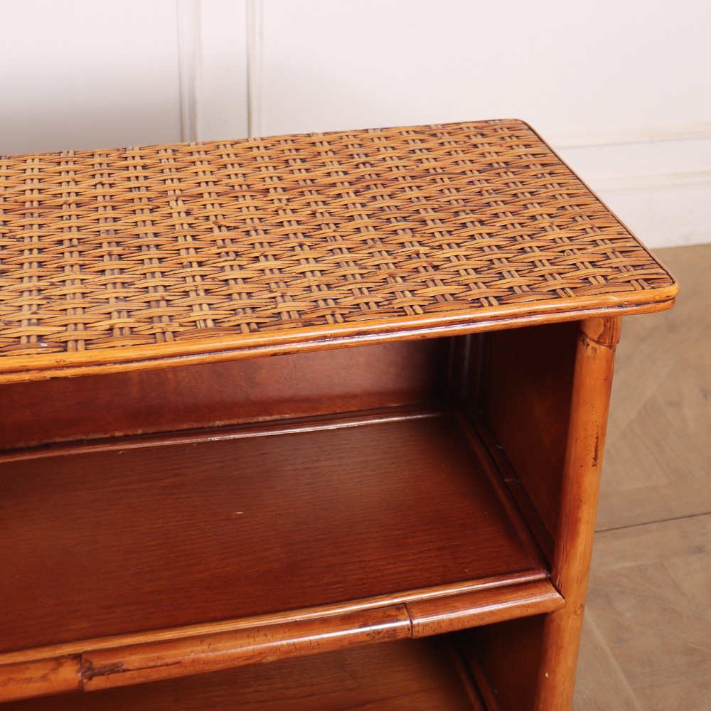 A pair of low vintage bamboo bookcases featuring woven cane tops and two open wooden shelves. View VII