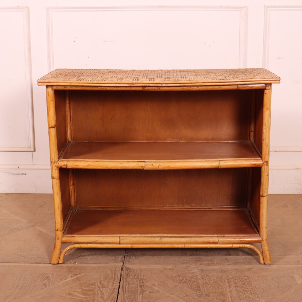 A pair of low vintage bamboo bookcases featuring woven cane tops and two open wooden shelves. View VIII