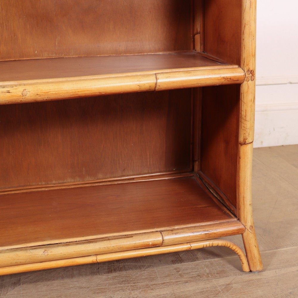 A pair of low vintage bamboo bookcases featuring woven cane tops and two open wooden shelves. View XI