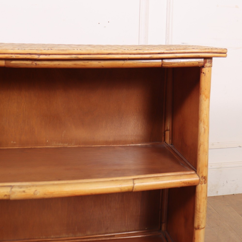 A pair of low vintage bamboo bookcases featuring woven cane tops and two open wooden shelves. View XII