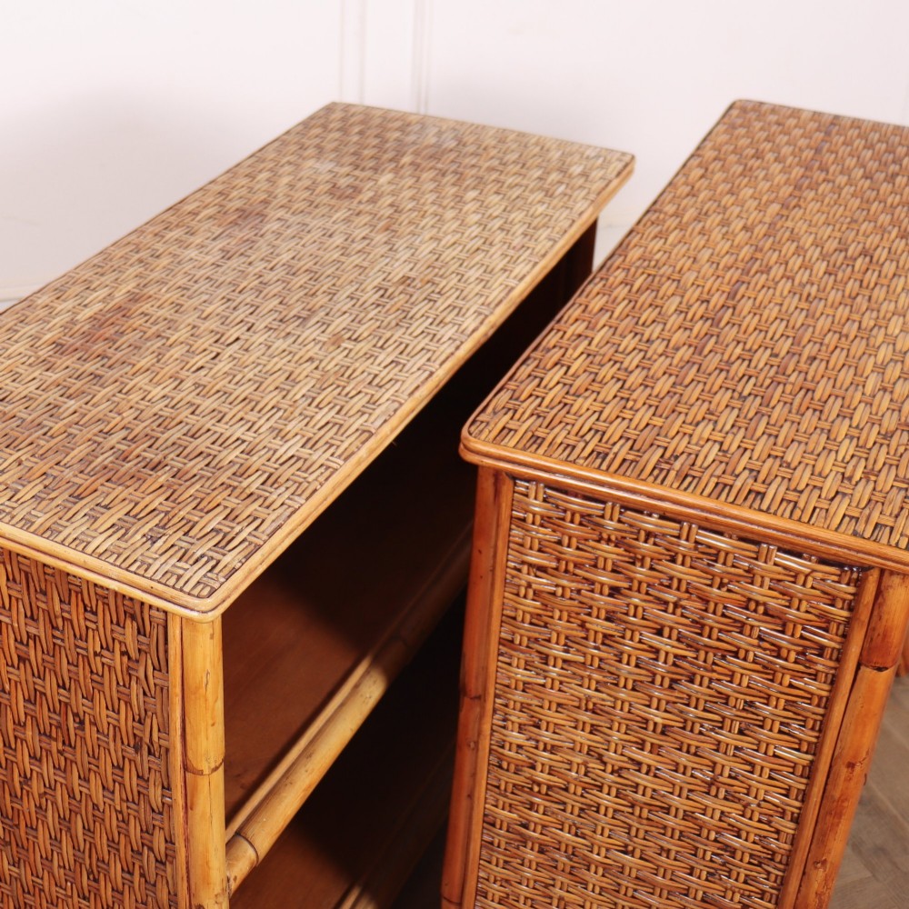 A pair of low vintage bamboo bookcases featuring woven cane tops and two open wooden shelves. View XIV