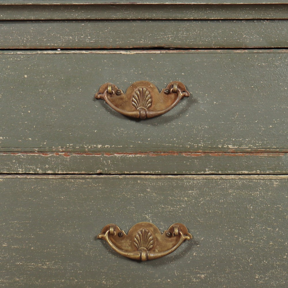 A distressed sage green painted wooden chest of drawers featuring two short over three long drawers with decorative brass handles and bracket feet. View VI