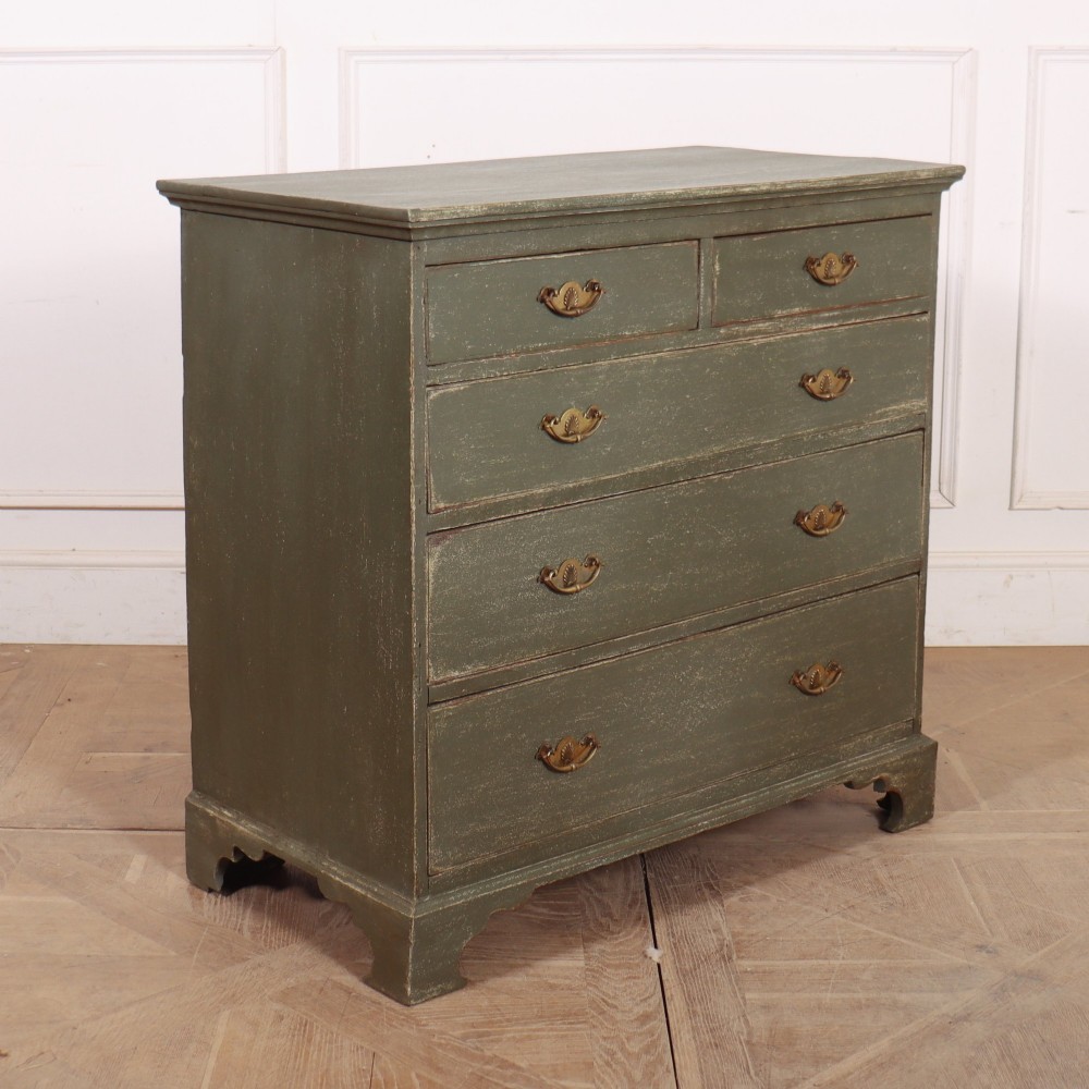A distressed sage green painted wooden chest of drawers featuring two short over three long drawers with decorative brass handles and bracket feet. View VII