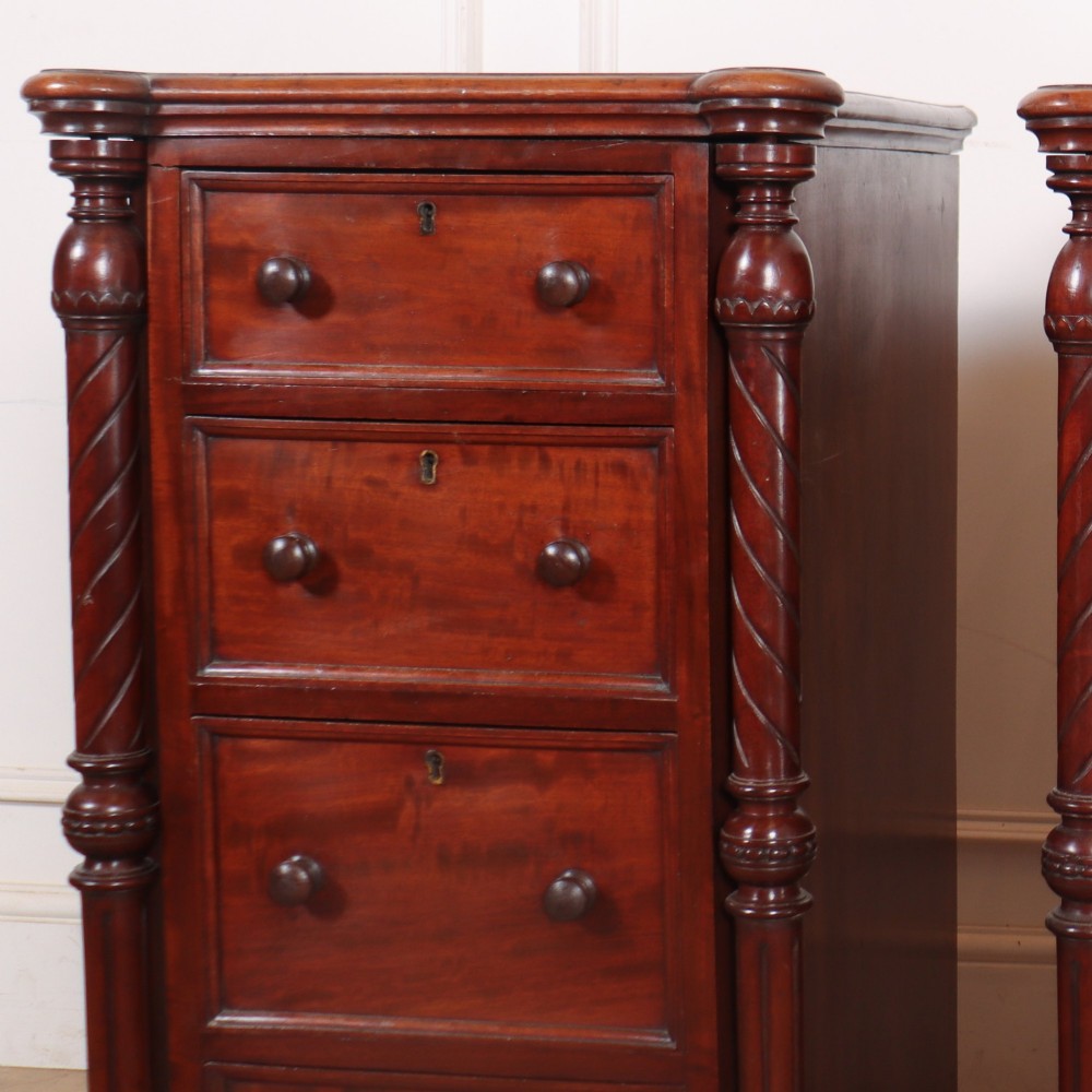 A matching pair of tall mahogany bedside chests featuring four drawers each, turned twist column pilasters, and round wooden handles. View IV