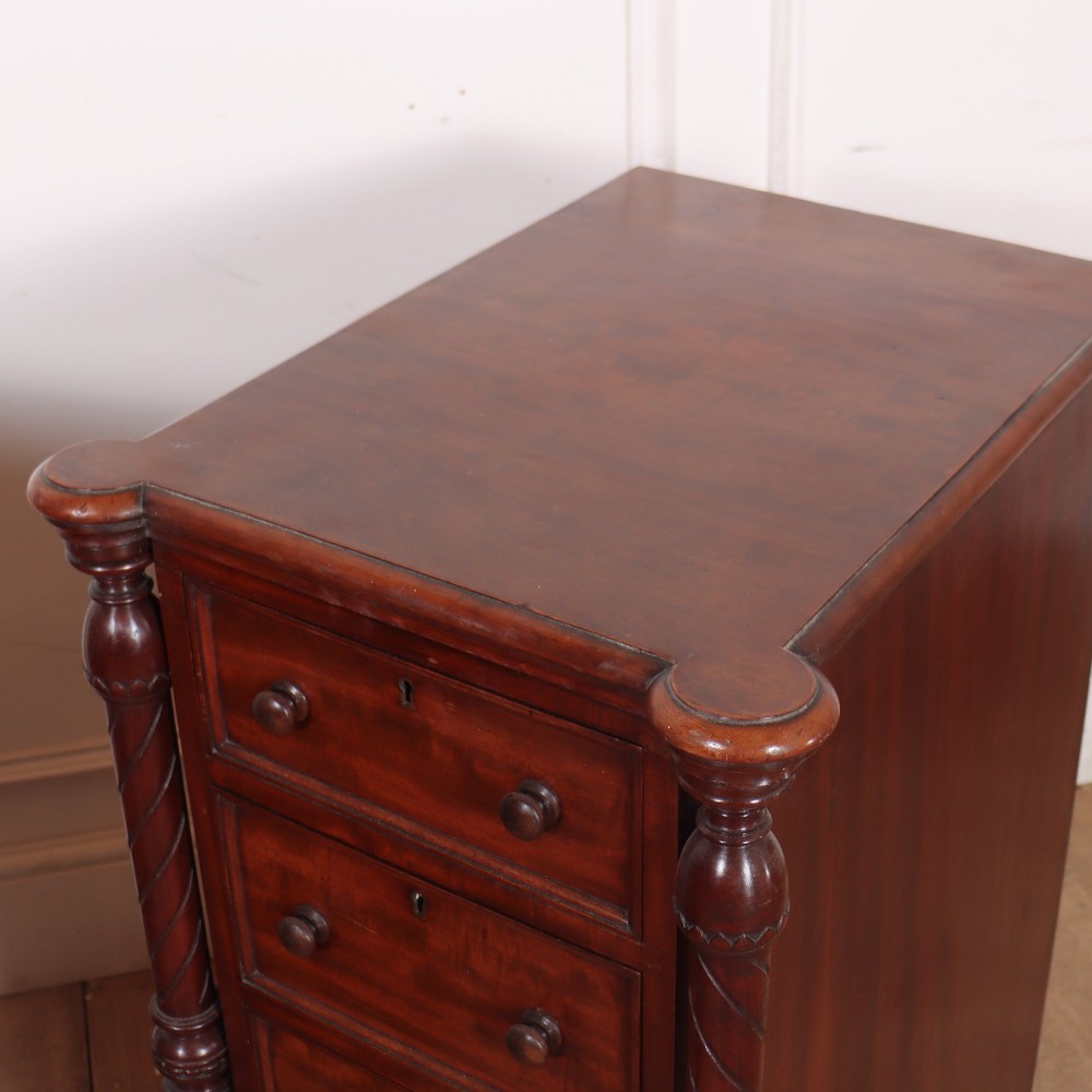 A matching pair of tall mahogany bedside chests featuring four drawers each, turned twist column pilasters, and round wooden handles. View VII