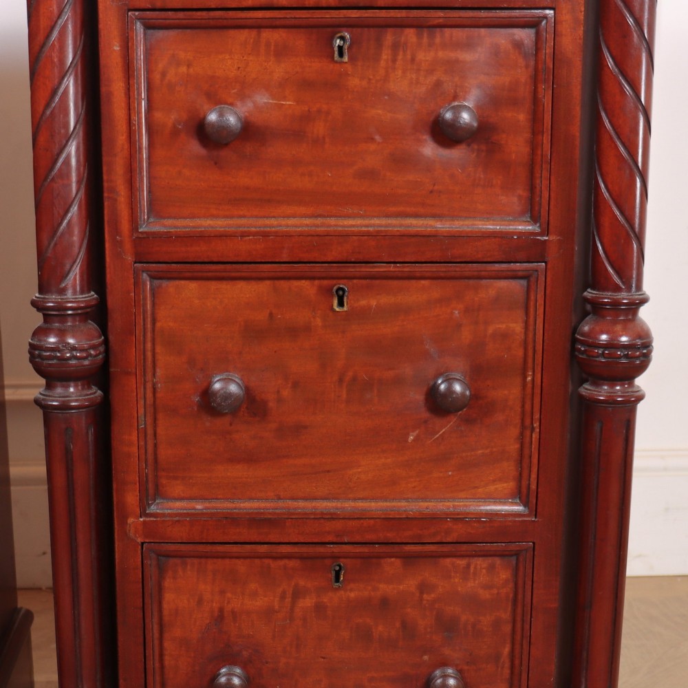 A matching pair of tall mahogany bedside chests featuring four drawers each, turned twist column pilasters, and round wooden handles. View VIII