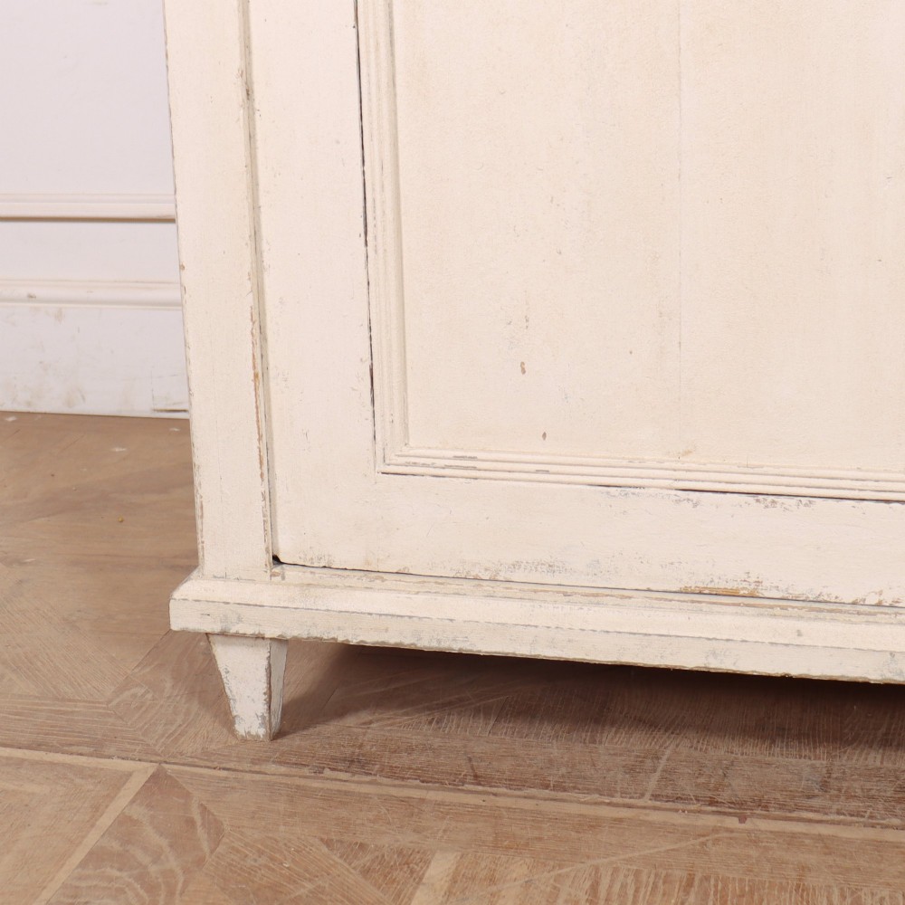 An off-white painted Continental wooden buffet featuring three reeded top drawers with round brass knobs above two large panelled cupboard doors and a grey painted top surface. View VI