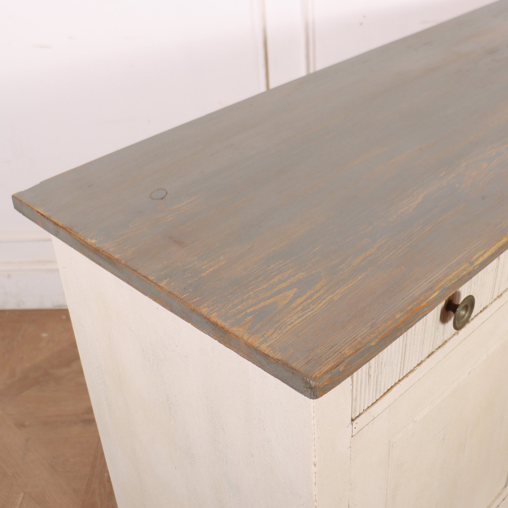 An off-white painted Continental wooden buffet featuring three reeded top drawers with round brass knobs above two large panelled cupboard doors and a grey painted top surface. View X