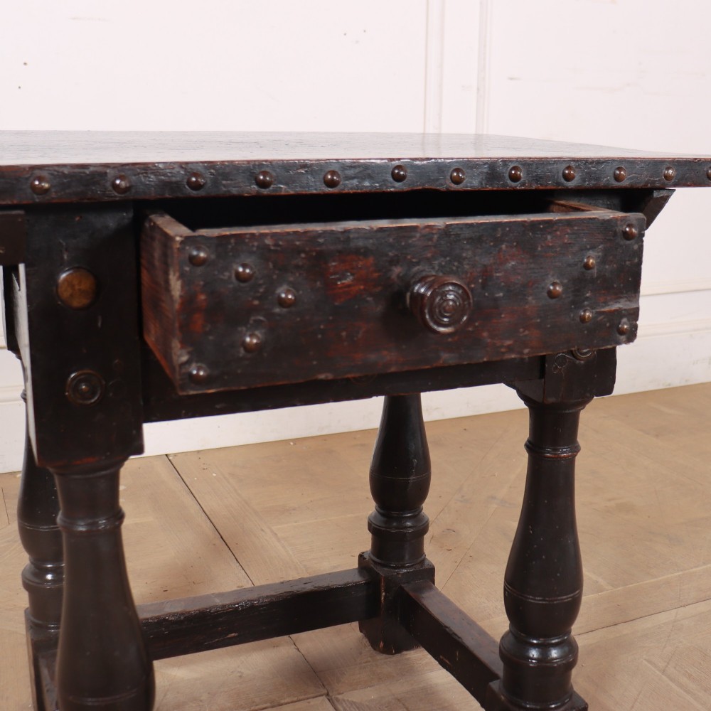 A dark brown Italian walnut side table featuring turned legs, a single frieze drawer, brass stud embellishments, and a low box stretcher. View VI