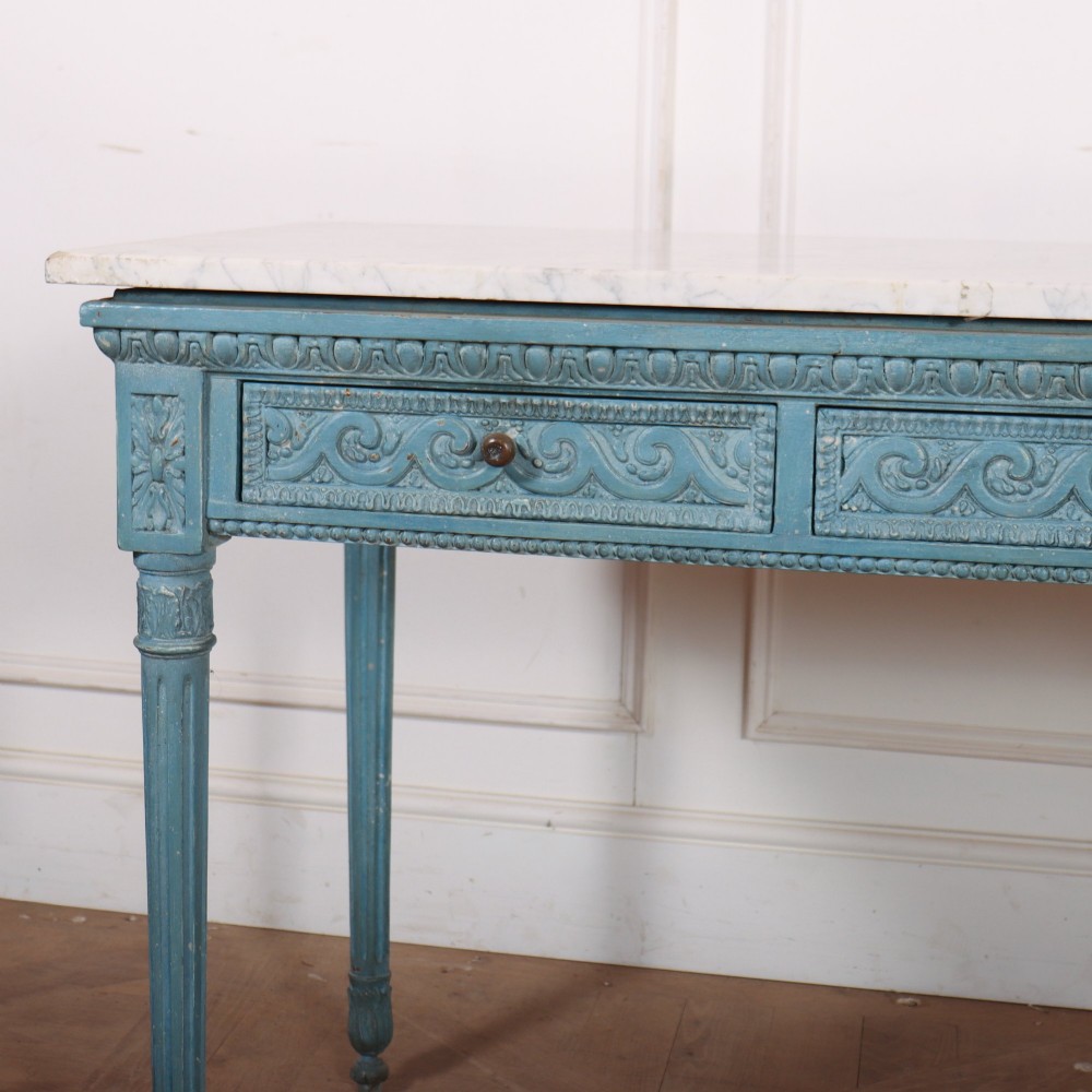 An Italian Neoclassical style light blue painted console table featuring a white marble top, three carved frieze drawers, and fluted legs. View II