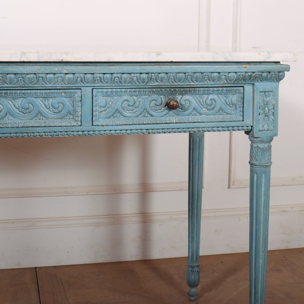 An Italian Neoclassical style light blue painted console table featuring a white marble top, three carved frieze drawers, and fluted legs. View III