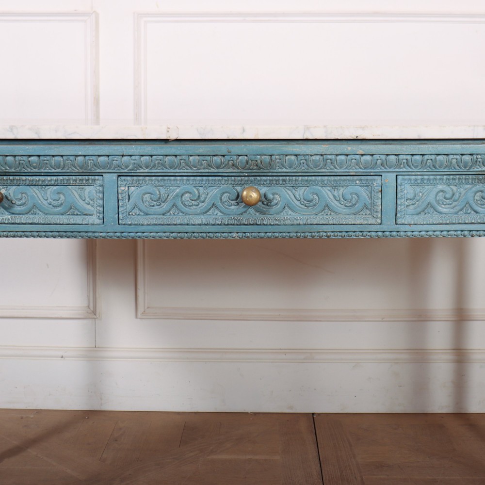 An Italian Neoclassical style light blue painted console table featuring a white marble top, three carved frieze drawers, and fluted legs. View IV